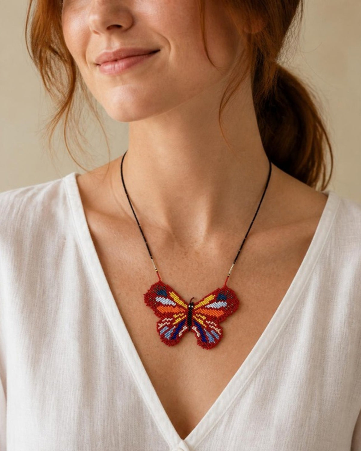 Model wearing Red Butterfly Beaded Pendant Necklace, handmade Colombian glass bead necklace